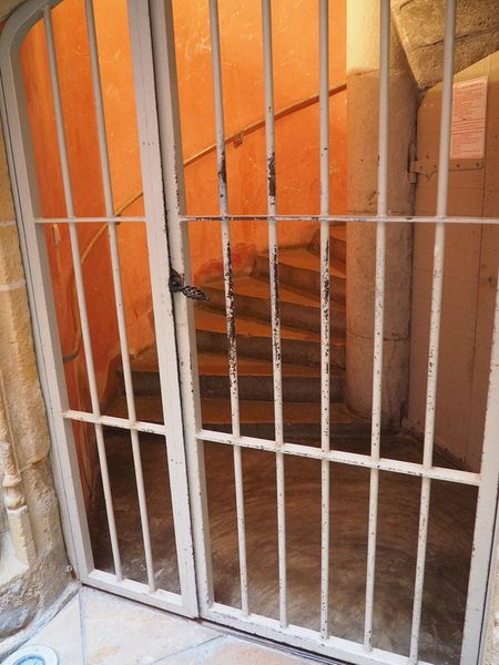 Spiral stone staircase behind bars